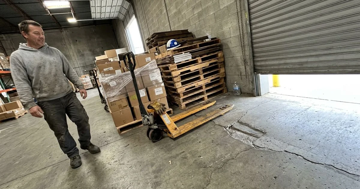 Warehouse floor with a visible dip near a loading dock, pallet jack parked beside it