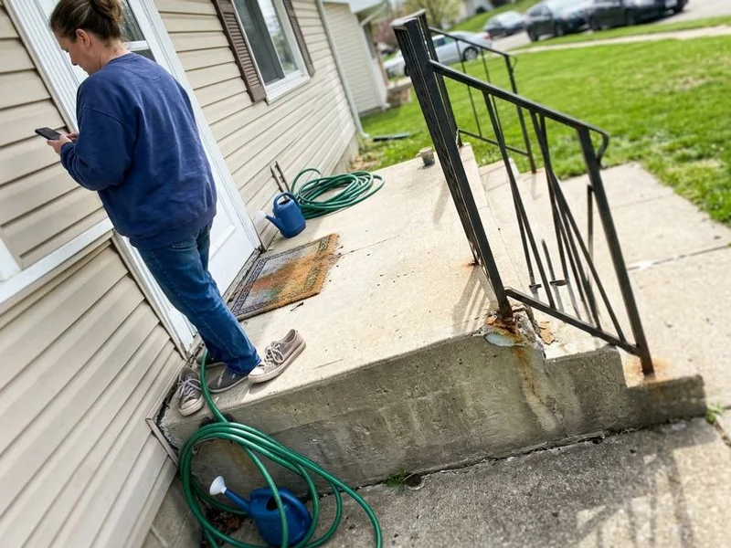 Concrete front stoop dropped at one corner with a separation gap at the house