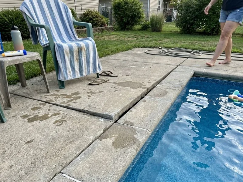 Concrete pool surround with a settled section beside the coping