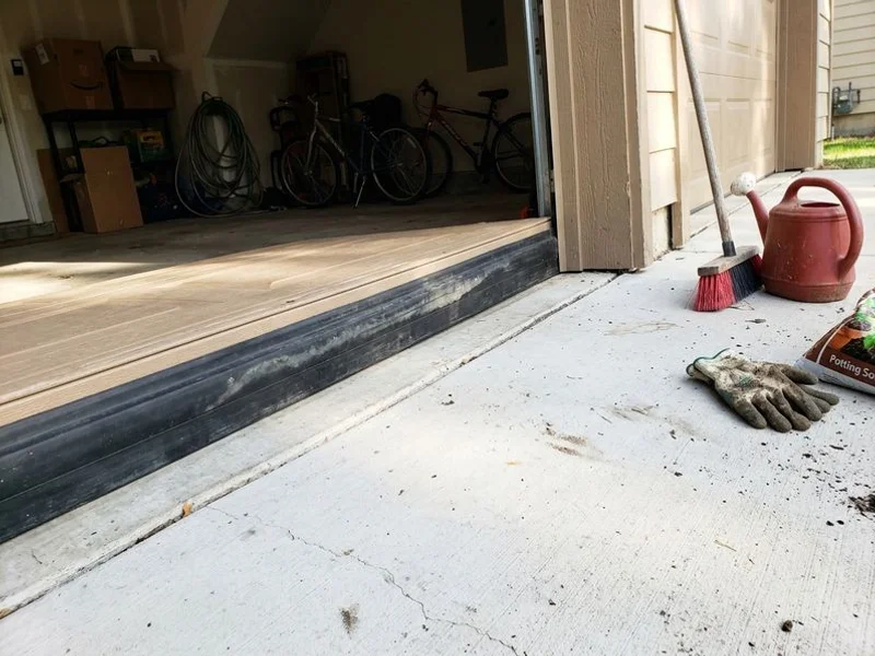 Garage door threshold meeting the lifted slab cleanly again with the weather seal in contact