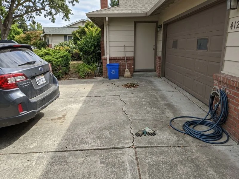 Settled two-car driveway with a step down at the garage apron before lifting
