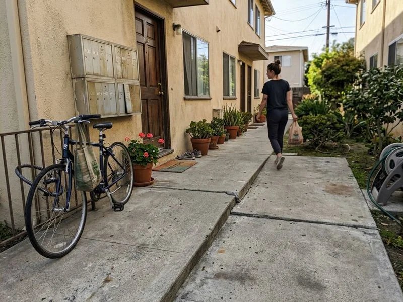 Shared walkway at a small multi-family property with an obvious stepped joint